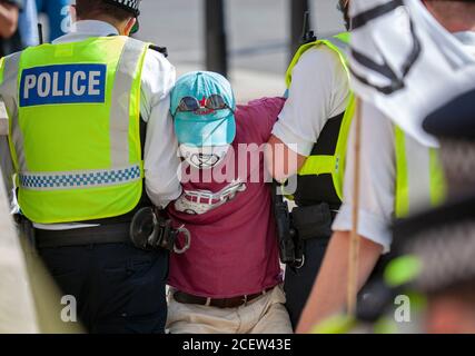 London, Großbritannien. September 2020. Extinction Rebellion Protestler wird von der Polizei nach ihrer Verhaftung, während des zweiten Tages von Demonstrationen vor dem parlament weggeschleppt. Frustriert über das Versagen der Regierung, auf die Klima- und ökologische Notlage zu reagieren, protestiert XR weiterhin für den Wandel. Der Climate and Ecological Emergency Bill (CEE Bill) ist der einzige konkrete Plan, der zur Verfügung steht, um diese Krise zu bewältigen, und so fordert XR in ihrer ersten Woche im Parlament die Regierung, jetzt zu handeln und diese Gesetzgebung anzunehmen. Quelle: Neil Atkinson/Alamy Live News. Stockfoto
