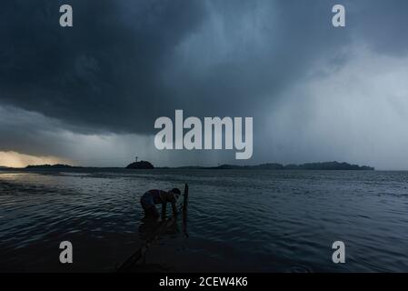 Guwahati, Assam, Indien. September 2020. Ein Fischhändler, der im Fluss Brahmaputra arbeitet, während sich dunkle Wolken am Himmel sammeln, in Guwahati. Quelle: David Talukdar/ZUMA Wire/Alamy Live News Stockfoto