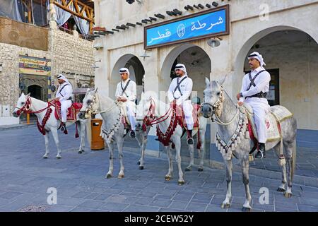 DOHA, Qatar-12 Dez 2019 - Ansicht der Katarischen berittene Polizei auf Pferde auf die Straße an der Souq Waqif im historischen Zentrum von Doha entfernt. Stockfoto