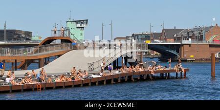 Kalvebod Bølge, Kalvebod Wellen an einem warmen, sonnigen Sommertag voll mit Sonnenbaden und Baden Menschen. Langebro Brücke im Hintergrund. Stockfoto