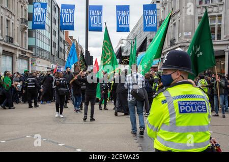 Ein Polizist schaut während des Ashura Day Events für schiitische Muslime, Oxford Circus, London, 30. August 2020 Stockfoto