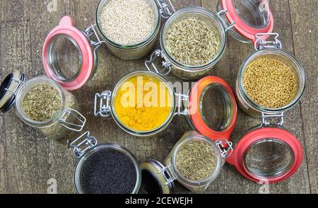 Draufsicht auf isolierte Einmachgläser mit Vielfalt an bunten Condiments auf Holztisch - Kunststoff-freies Verpackungskonzept Stockfoto