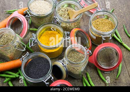 Draufsicht auf isolierte Einmachgläser mit Vielfalt an bunten Condiments auf Holztisch - Kunststoff-freies Verpackungskonzept Stockfoto