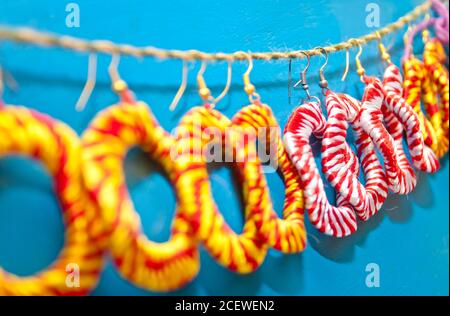 Bunte handgemachte Ohrringe werden in Geschäften zum Verkauf angezeigt. Stockfoto