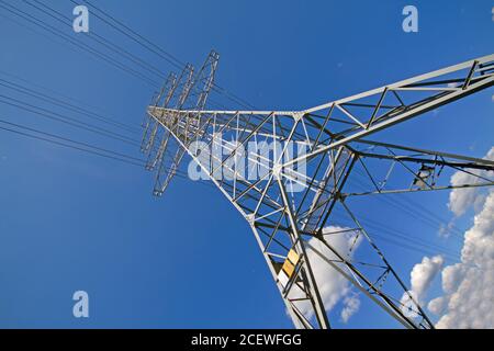 Strommast mit Drähten gegen blauen Himmel Stockfoto