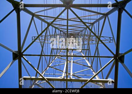Strommast mit Drähten gegen blauen Himmel Stockfoto