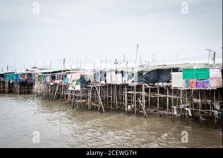 Häuser auf Stelzen Klammern sich an einen Pier am Bang Saen Beach, in der Nähe von Pattaya Thailand. Stockfoto