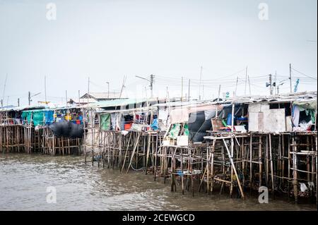 Häuser auf Stelzen Klammern sich an einen Pier am Bang Saen Beach, in der Nähe von Pattaya Thailand. Stockfoto