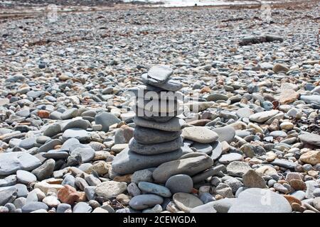 Balancing Kieselsteinturm an einem Kieselsteinstrand in Criccieth, North Wales Stockfoto