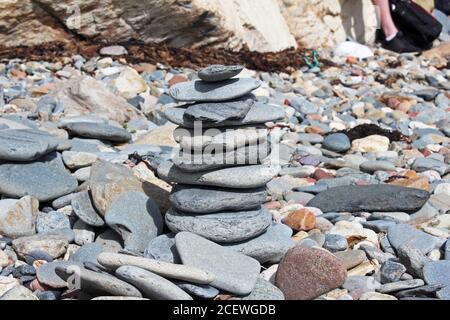 Balancing Kieselsteinturm an einem Kieselsteinstrand in Criccieth, North Wales Stockfoto