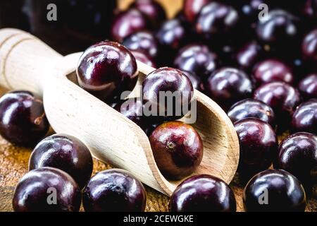 Brasilianische Frucht genannt jaboticaba oder jabuticaba, ist die einheimische Traube von Brasilien. Plinia cauliflora Arten, auf einem rustikalen Tisch, exotische Früchte, anti-infla Stockfoto