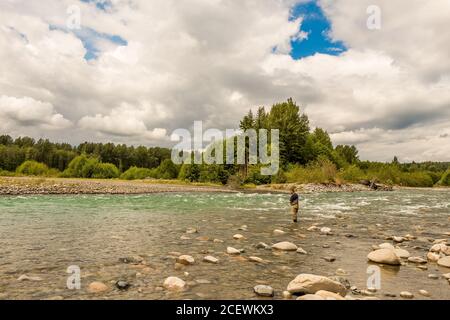 Ein Fliegenfischer, der den schnell fließenden, grünen Gletscherfluss des Kitimat River angeln kann, im Nordwesten von British Columbia, Kanada. Stockfoto