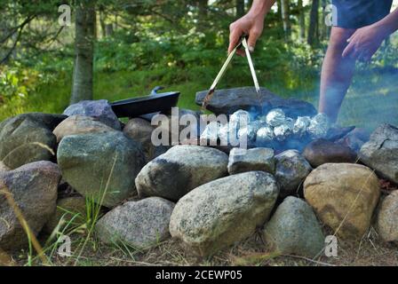 Kochen von Mais auf dem Cob über einem Lagerfeuer Stockfoto