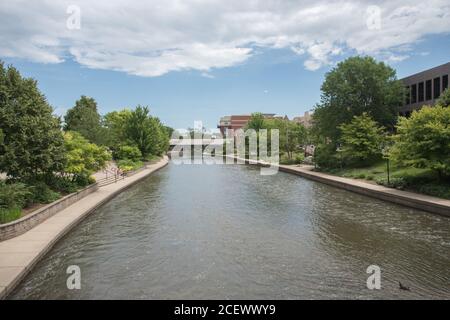 Naperville, Illinois, USA-24. April 2014: DuPage River Riverwalk mit Touristen, Gebäuden und überdachter Brücke in Naperville, Illinois Stockfoto