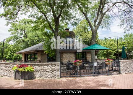 Naperville, Illinois, USA-April 24, 2014: Riverwalk Cafe Gebäude mit Innenhof für Sitzgelegenheiten und Blumen in Naperville, Illinois Stockfoto