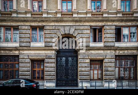 Budapest, Ungarn, August 2019, Blick auf ein altes Gebäude mit einem schwarzen schmiedeeisernen Tor im Zentrum der Hauptstadt Stockfoto