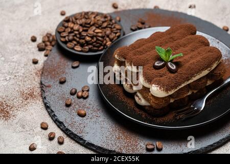 Klassisches Tiramisu Dessert auf Keramikplatte auf Betongrund Stockfoto
