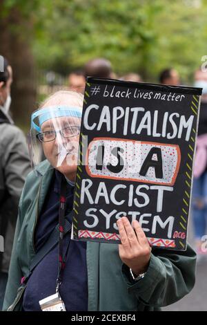 Ein älterer Mann, der ein Gesichtsvisier trägt und ein Schild an der Million People March hält, London, 30. August 2020 Stockfoto