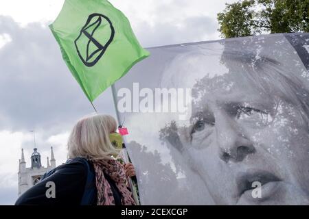 Nach einer verschobenen Pause wegen der Coronavirus-Pandemie protestieren Klimaaktivisten am 2. September 2020 mit einem Transparent mit dem Bild von Premierminister Boris Johnson auf dem Parliament Square in London, England. Stockfoto