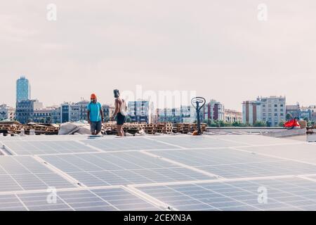 Reihen von modernen Solarbatterien installiert im Hof der zeitgenössischen Pflanze an sonnigen Tag Stockfoto