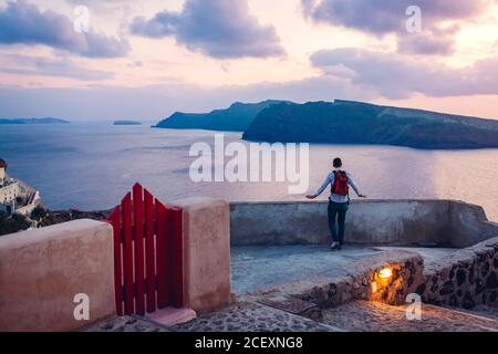 Santorini Insel Oia Sonnenuntergangslandschaft. Touristen genießen Caldera Meerblick in der Dämmerung auf dem Dach. Reise nach Griechenland. Stockfoto