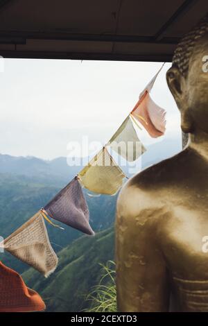 Detail der traditionellen buddhistischen Statue und Fahnen in orientalischen Schrein Auf dem Hintergrund der Hochlandlandschaft in Sri Lanka Stockfoto