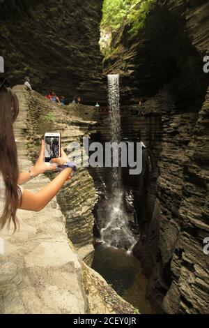 Junge Person, die ein Bild von den Rainbow Falls im Watkins Glen State Park, NY, USA, macht Stockfoto