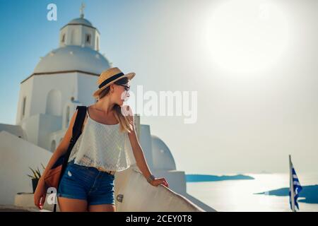 Frau Touristen genießen Caldera Meereslandschaft in Fira, Santorini Insel zu Fuß durch traditionelle weiße Kirche. Stockfoto