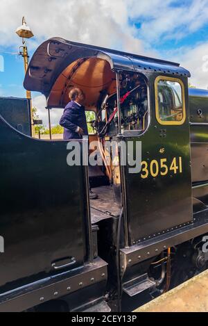Zugfahrer, der die Rocket Black Dampflokomotive für die Abfahrt auf der Bluebell Heritage Eisenbahnlinie, Sheffield Park, East Sussex, England, Großbritannien vorbereitet Stockfoto