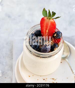 Von oben hausgemachter Cashew veganer Joghurt auf Gläsern serviert Auf weißem rustikalem Tisch Stockfoto