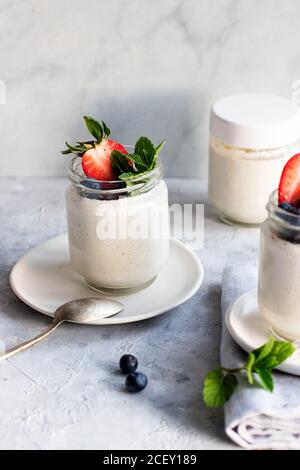 Von oben hausgemachter Cashew veganer Joghurt auf Gläsern serviert Auf weißem rustikalem Tisch Stockfoto