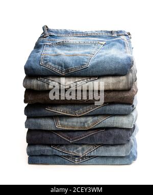 Viele gebrauchte Jeans in einem Stapel isoliert auf gestapelt Weiß Stockfoto