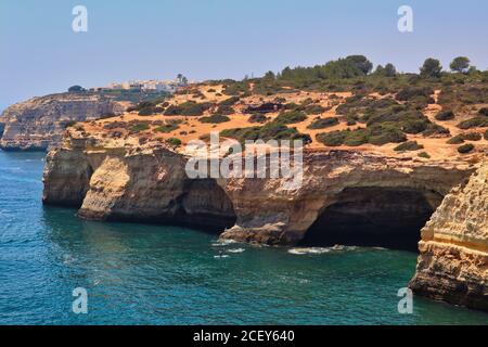 Sandsteinfelsen, die die Benagil-Höhle an der Algarve bilden. Grotte mit Atlantik davor. Stockfoto