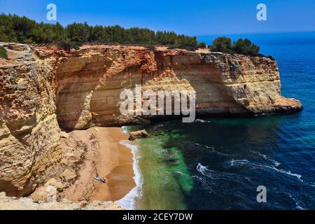 Ein Bild von einem Strand mit atlanischem Ozean und seinen Wellen, Sandsteinklippen auf dem Weg, um Benagil Höhle von oben zu sehen. Stockfoto
