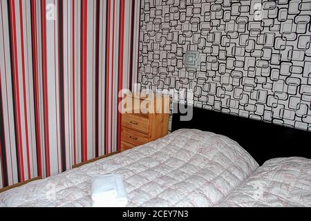 Schlafzimmer innen in Holz Landhaus, Holz Nachttisch und Nahaufnahme des Bettes mit weichen weißen Decke Stockfoto