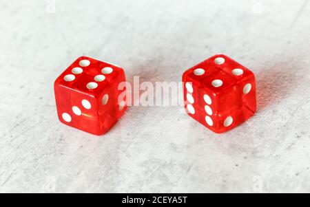 Zwei durchscheinende rote Würfelwürfelwürfelchen auf weißem Brett, das einfach zeigt Zehn (Zahl 6 und 4) Stockfoto