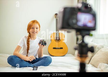 Portrait von lächelnd kaukasischen Mädchen zeigen neue moderne Technologie-Gerät bei der Kamera. Professionelle Kamera auf rothaarige Mädchen zeigt Gerät ausgerichtet, sprechen Sie mit s Stockfoto