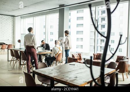 Selbstbewusste Geschäftsleute Coworking im Büro, in formellen Kleidern, eleganten Smoking. Männer halten Sitzung im Sitzungssaal für Diskussion und Zusammenarbeit. b Stockfoto