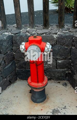 Alte rote Feuerlöschschlauch-Anschluss auf dem Bürgersteig, Lanzarote Island, Kanarische Inseln Spanien Stockfoto