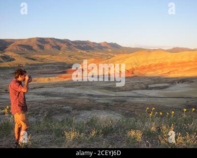 Die letzten Strahlen der untergehenden Sonne Licht von einem Fotografen die Klippen weit hinter den Painted Hills eingefangen. Oregon, USA. Stockfoto