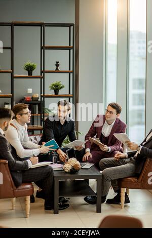 Erfolgreiche, selbstbewusste Geschäftskollegen sitzen im Büro und haben Brainstorming Zeit, denken über die Entwicklung ihres Unternehmens, wie das Problem zu lösen Stockfoto