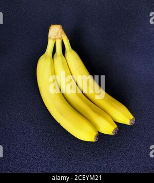 Drei reife Bananen auf dunklem Hintergrund Stockfoto