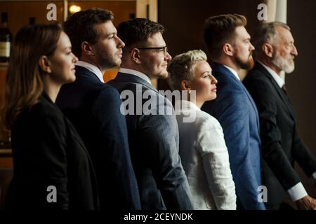 Porträt selbstbewusster reservierter Menschen in Business-Suiten, die gerade stehen und mit tolerantem Ausdruck wegschauen. Nahaufnahme Stockfoto