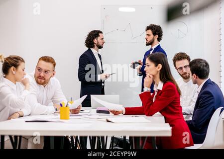 Junge Business-Mitarbeiter im Büro, diskutieren Ideen und Projekte gemeinsam mit Partnern im modernen Büro, erfolgreiches Zusammenspiel verschiedener Partner Stockfoto