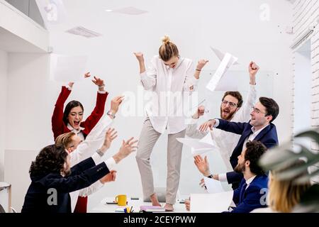 Junge Geschäftsleute genießen, glücklich zusammen im Geschäftsbüro, nach dem Treffen, Abschluss des Geschäftsprojekts, Mitarbeiter in formeller Kleidung Stockfoto