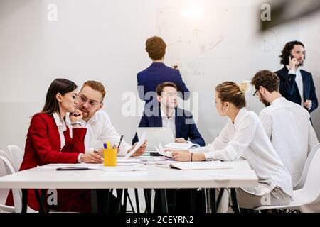 Brainstorming von jungen erfolgreichen Geschäftsleuten versammelt, um neue Geschäftsstrategien, Ideen gemeinsam in modernen Büro, erfolgreiche Interaktion zu diskutieren Stockfoto