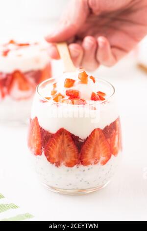 Frühstück mit griechischem Joghurtglas mit Chia und Erdbeeren. Stockfoto