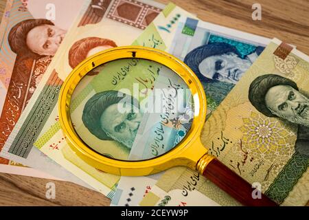 Iranisches Geld, Rials, verschiedene Papierbanknoten unter einer Lupe, Country Economy Konzept Stockfoto