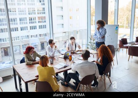 Kreative und enthusiastische Business-Gruppe sitzen im Büro zusammen arbeiten als Team, tragen formale Kleidung. Kaukasische Geschäftsleute Stockfoto