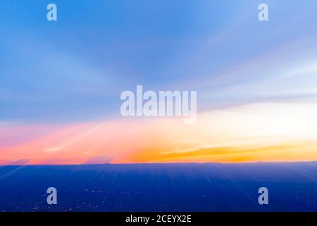 Abstrakter Himmel und Stadtlicht verwischen sich bei Sonnenuntergang über der Landschaft von Sandia Peak, Albuquerque, New Mexico, USA. Stockfoto